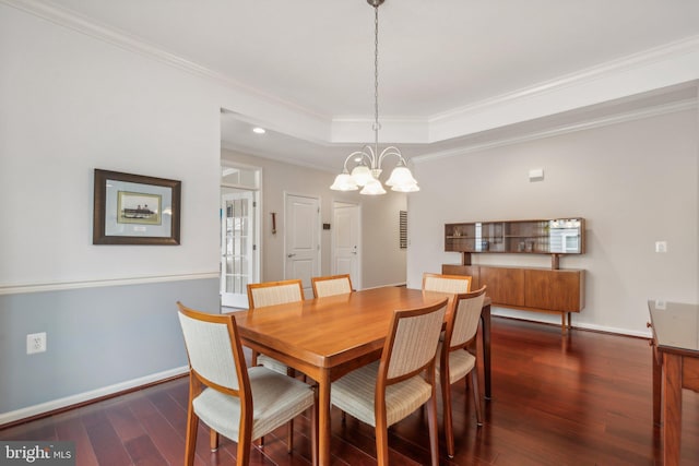 dining room featuring a tray ceiling, crown molding, dark hardwood / wood-style flooring, and a chandelier