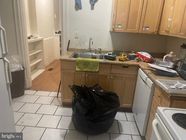 kitchen featuring light tile patterned floors, white appliances, and sink