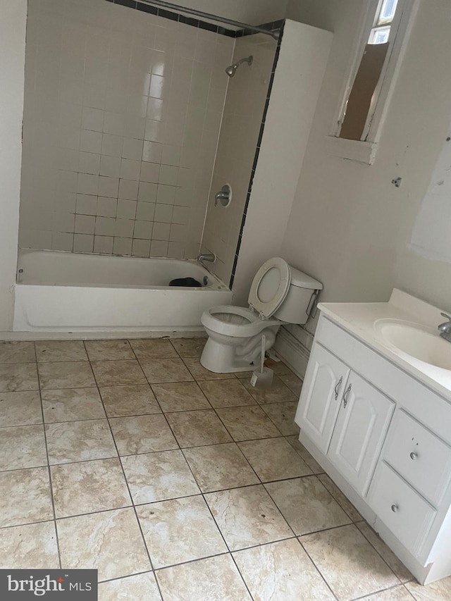 full bathroom with tile patterned floors, vanity, tiled shower / bath combo, and toilet