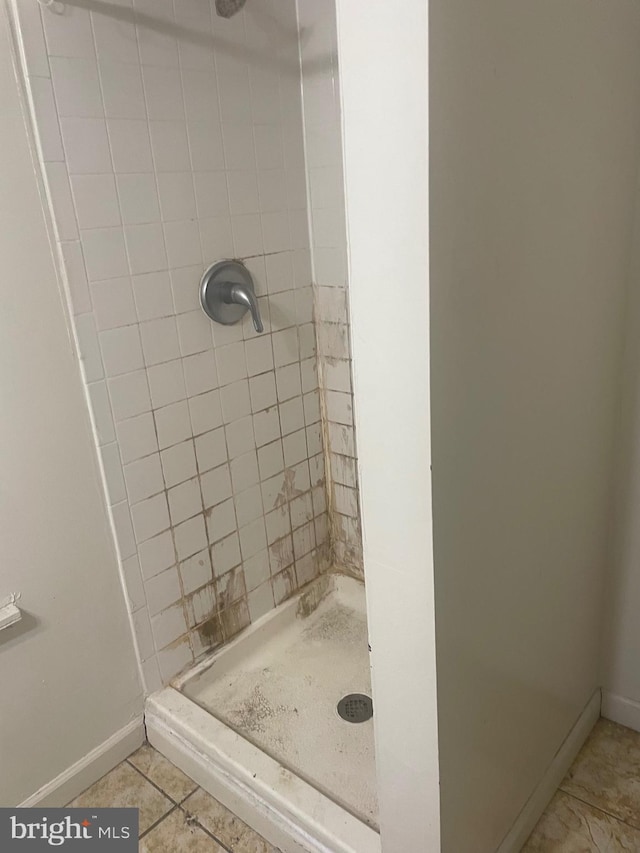 bathroom featuring tile patterned flooring and tiled shower