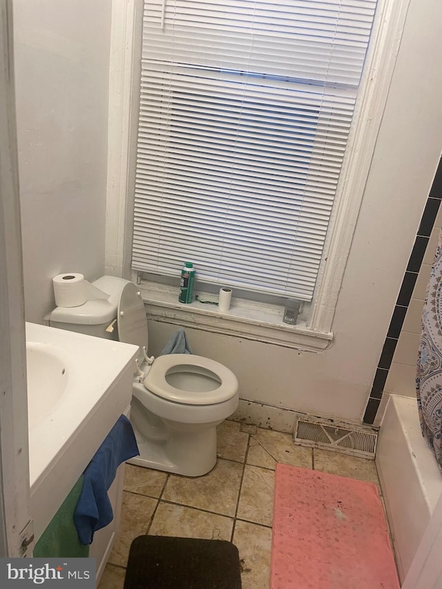 bathroom with toilet, shower / bath combination with curtain, and tile patterned floors