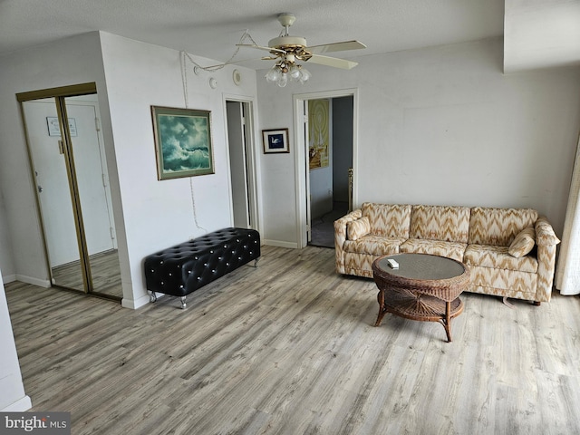 living room featuring ceiling fan and light hardwood / wood-style flooring