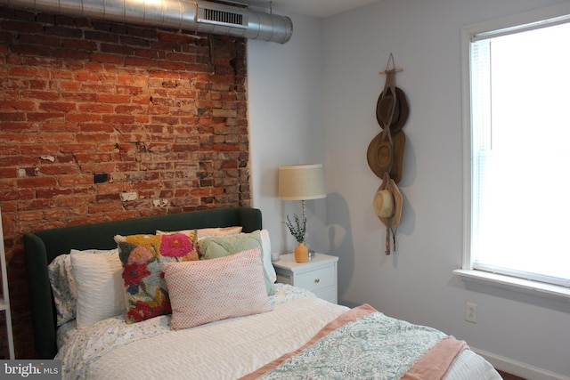 bedroom featuring brick wall