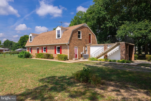 view of front of property with central AC unit and a front yard