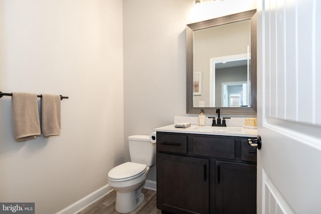 bathroom featuring vanity, wood-type flooring, and toilet