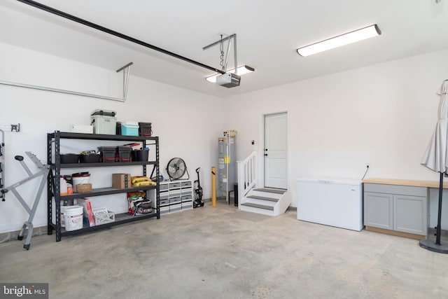 garage with electric water heater, a garage door opener, and refrigerator