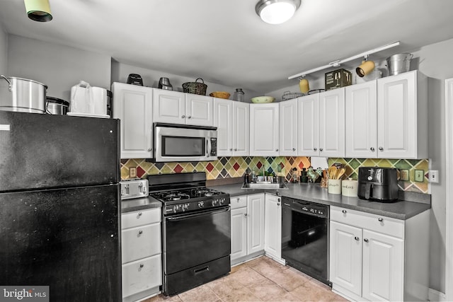 kitchen with backsplash, black appliances, sink, light tile patterned floors, and white cabinetry