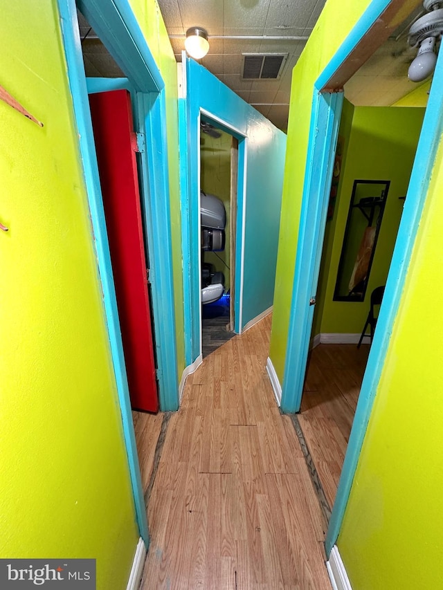 hallway with a drop ceiling and light hardwood / wood-style floors