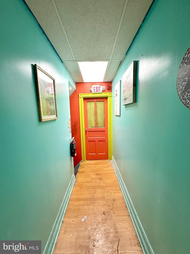 corridor featuring a paneled ceiling and light hardwood / wood-style floors