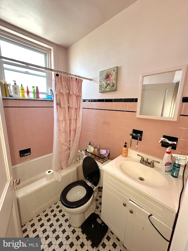 full bathroom with vanity, shower / bath combination with curtain, tile patterned flooring, toilet, and tile walls