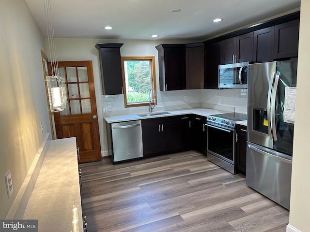 kitchen with light hardwood / wood-style floors, sink, backsplash, and stainless steel appliances