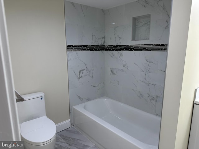 bathroom featuring tile patterned flooring, tiled shower / bath combo, and toilet