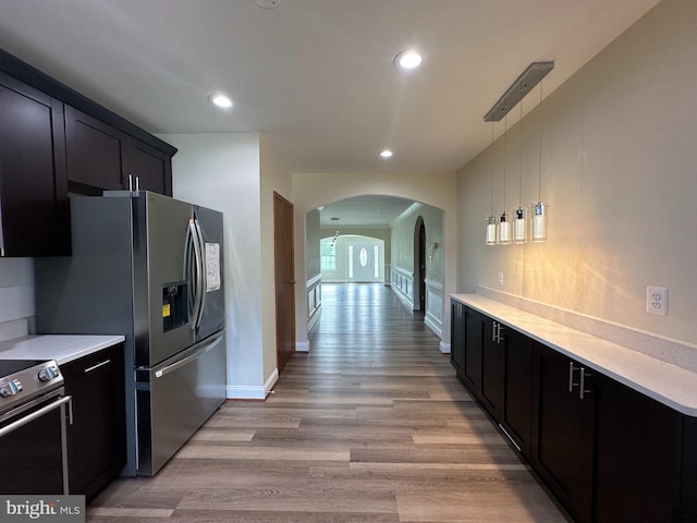 kitchen featuring appliances with stainless steel finishes, pendant lighting, and light wood-type flooring