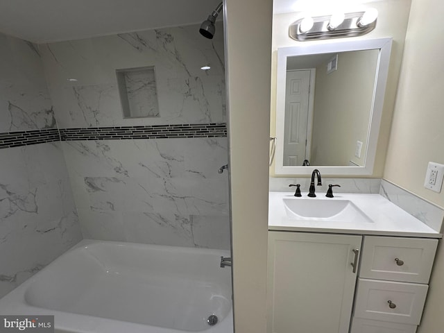 bathroom with tiled shower / bath combo and vanity