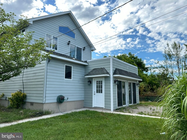 rear view of house featuring a yard