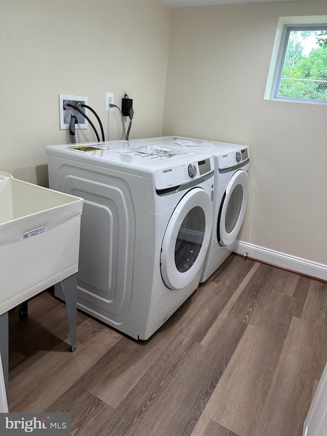 laundry area featuring washing machine and dryer and hardwood / wood-style floors