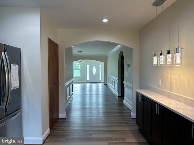 corridor with wood-type flooring and crown molding