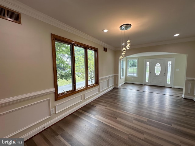 spare room featuring dark hardwood / wood-style flooring and crown molding