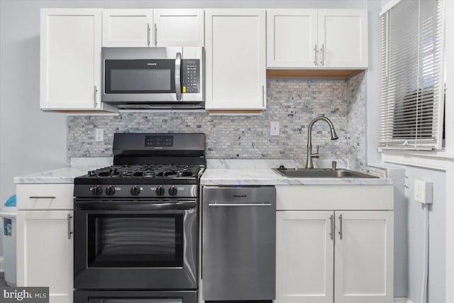 kitchen featuring white cabinets, decorative backsplash, sink, and appliances with stainless steel finishes