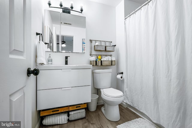 bathroom featuring hardwood / wood-style flooring, ceiling fan, toilet, and vanity