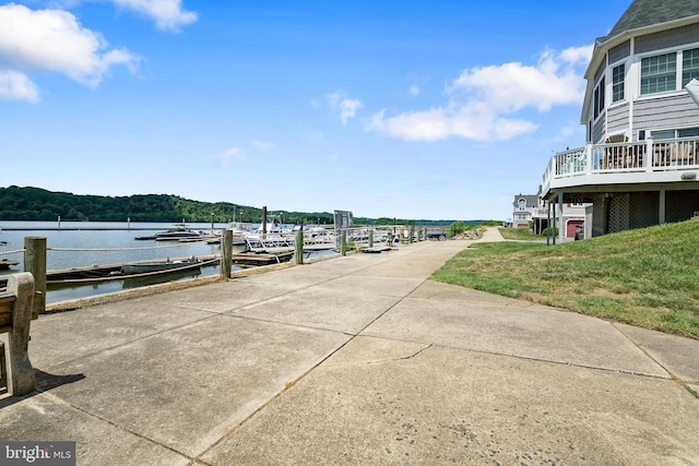 view of dock with a yard and a water view