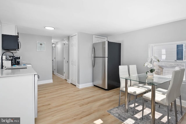 dining area with sink and light hardwood / wood-style floors