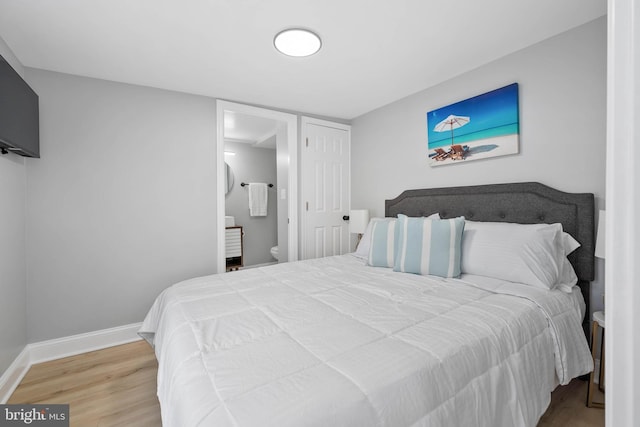 bedroom featuring ensuite bath and hardwood / wood-style flooring