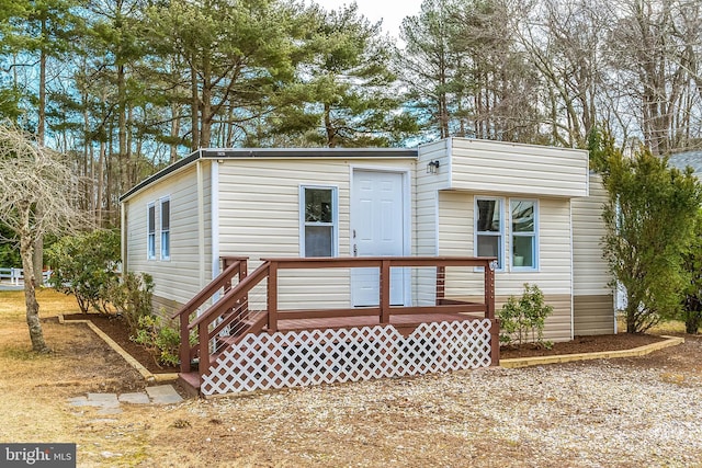 rear view of property featuring a wooden deck