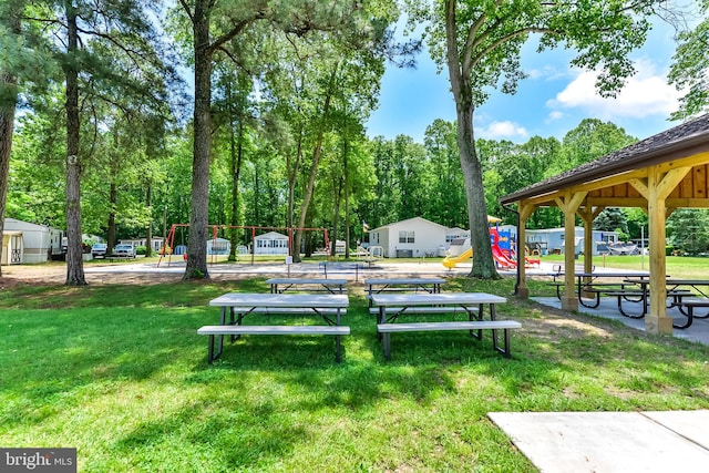 view of home's community featuring a playground and a yard