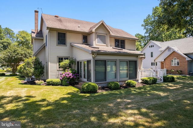 back of property featuring a sunroom and a yard