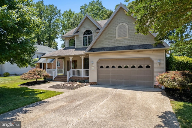 view of front of house featuring a porch, a garage, and a front lawn