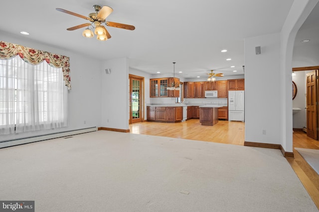 unfurnished living room featuring light carpet, baseboard heating, and ceiling fan