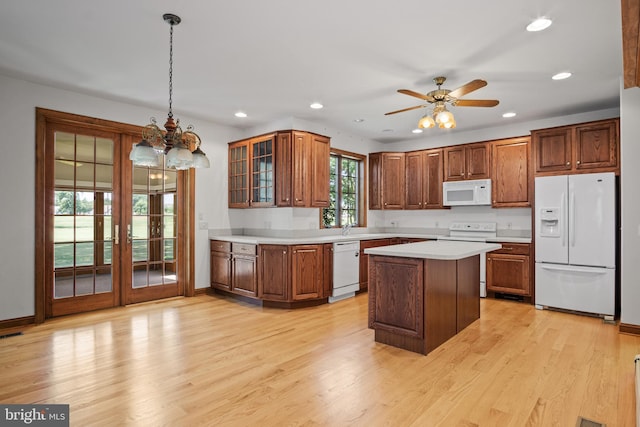 kitchen featuring ceiling fan with notable chandelier, white appliances, decorative light fixtures, and light hardwood / wood-style flooring