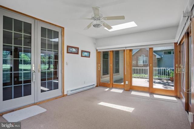 unfurnished sunroom featuring ceiling fan, baseboard heating, and a skylight