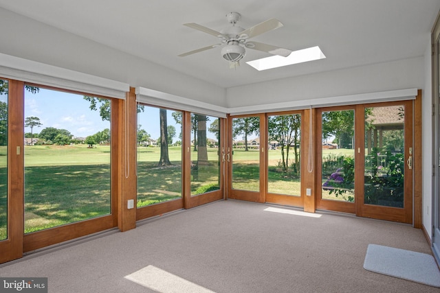 unfurnished sunroom with ceiling fan and a skylight