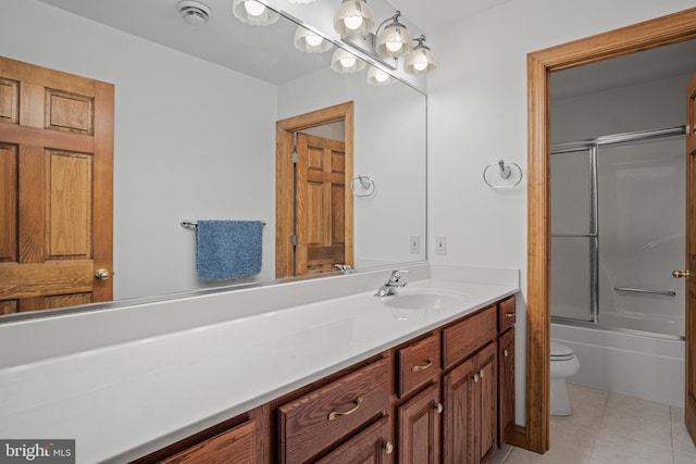 full bathroom featuring tile patterned flooring, vanity, toilet, and bath / shower combo with glass door