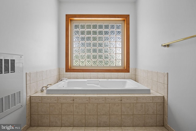 bathroom featuring tiled tub, heating unit, and tile patterned flooring