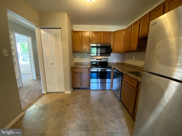 kitchen featuring carpet floors and stainless steel appliances