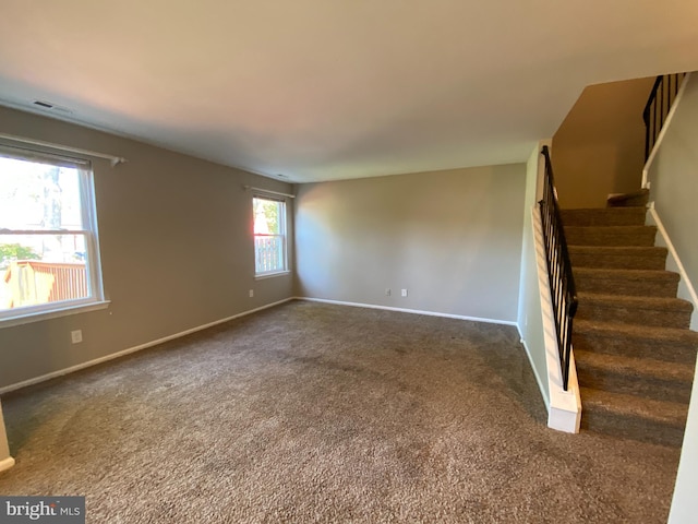 unfurnished room featuring dark carpet