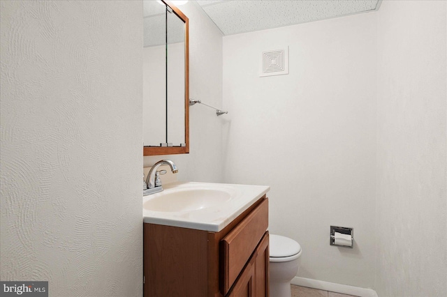 bathroom featuring vanity, toilet, and a textured ceiling