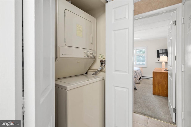 laundry area with light tile patterned flooring, stacked washer and dryer, and baseboard heating