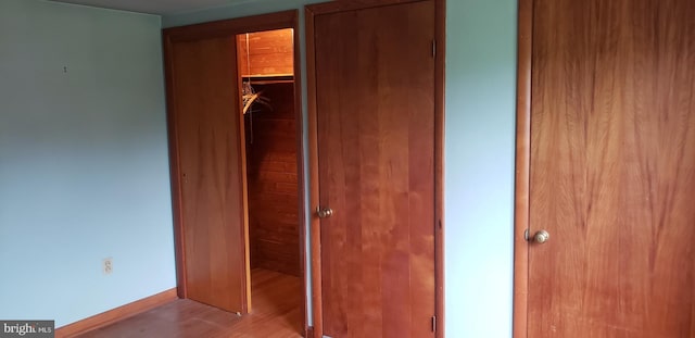 unfurnished bedroom with a closet and light wood-type flooring