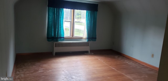 empty room with hardwood / wood-style flooring and radiator