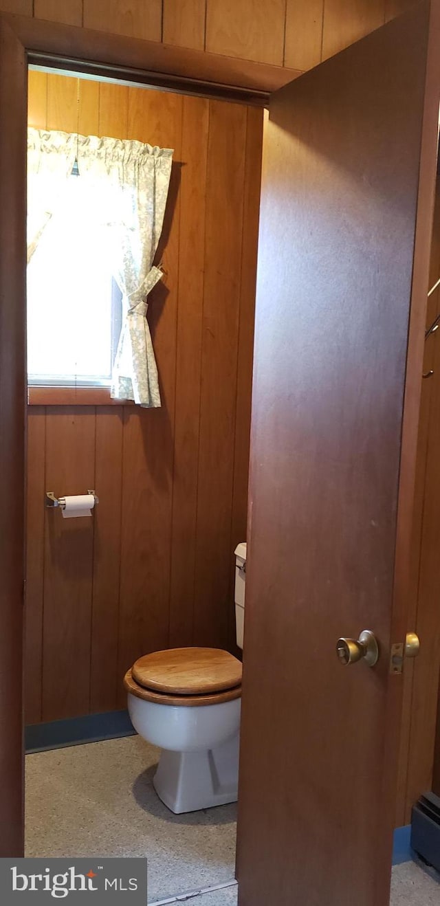 bathroom with wooden walls and toilet