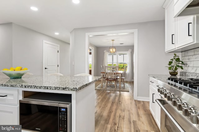 kitchen with white cabinets, stainless steel appliances, and extractor fan