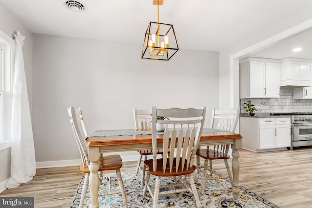 dining room with a notable chandelier and light hardwood / wood-style floors