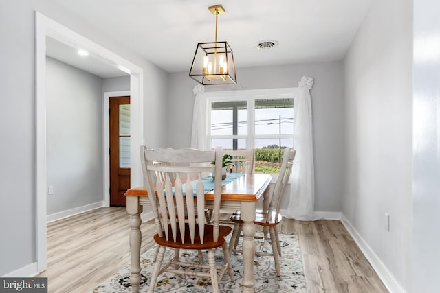 dining room with a chandelier and light wood-type flooring