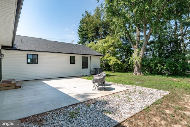 rear view of property featuring central air condition unit, a patio area, and a yard