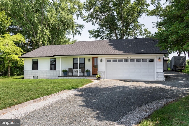 single story home featuring a garage, covered porch, and a front lawn