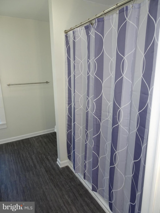 full bath featuring wood finished floors and baseboards